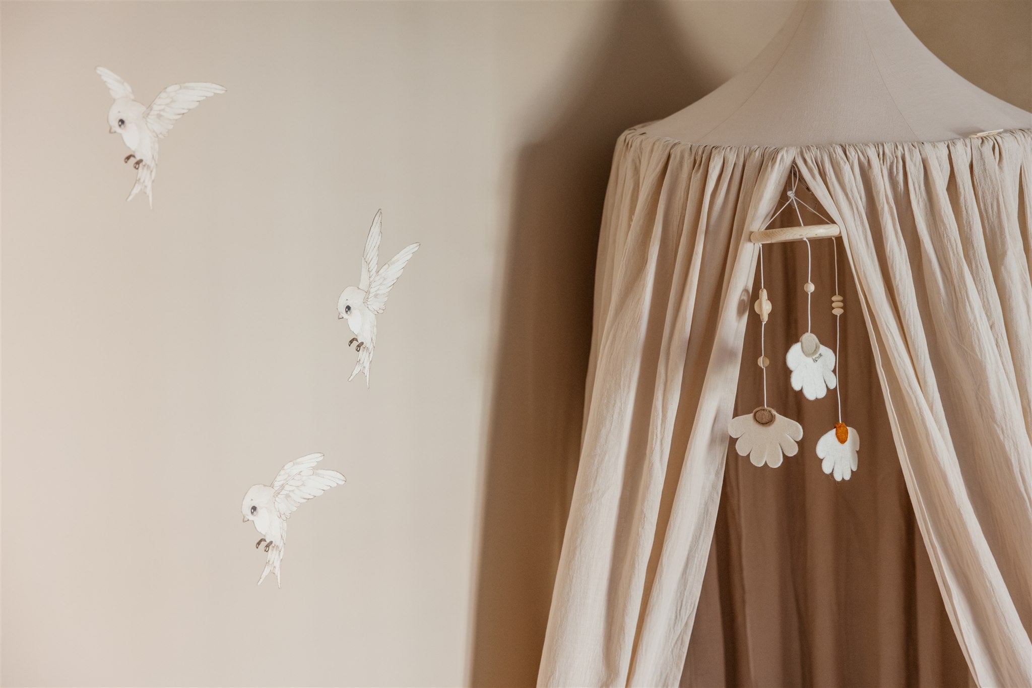 Babykamer meisje met muurstickers vogels en bedhemeltje