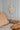 Close up van bed, wandlamp en lijntjesbehang denim en beige